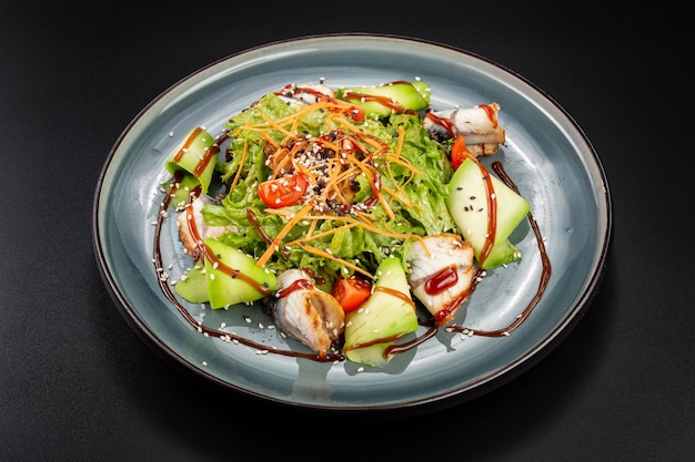 Salada de enguia delicada em uma superfície preta