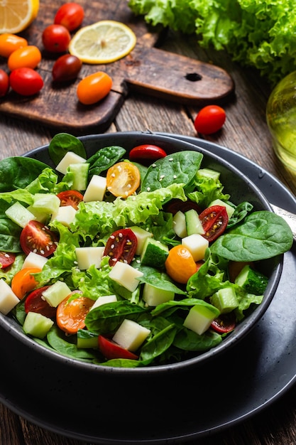 Salada de espinafre, tomate cereja e queijo em um prato