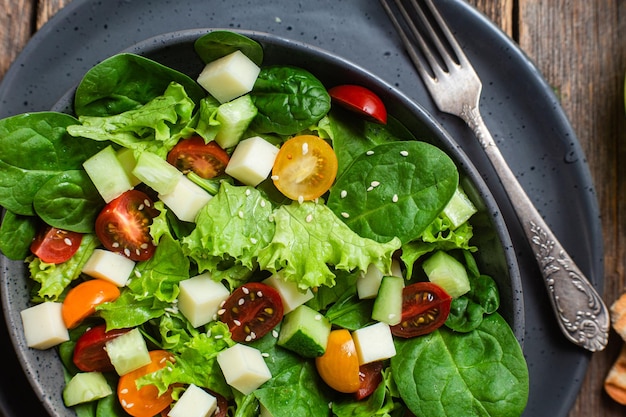 Salada de espinafre, tomate cereja e queijo em um prato