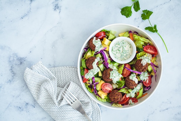 Salada de falafel com tomate abacate e molho de tahine