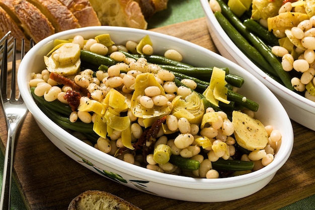 Salada de feijão branco nutritiva Cannellini com feijão verde tomate seco e alcachofra em óleo Comida italiana tradicional