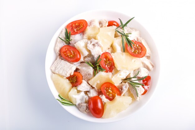 Salada de filé de frango com alecrim, abacaxi e tomate cereja isolado no branco