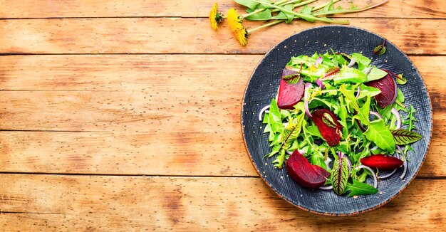 Salada de folhas verdes e beterraba, mesa de madeira