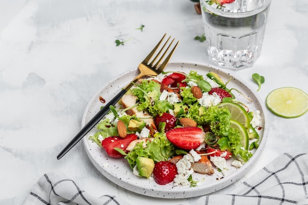 Salada de fruta de verão morango com abacate de carne de frango, queijo feta, vinagre balsâmico de alface e nozes, alimentos saudáveis de conceitos.