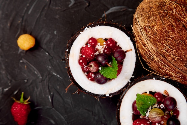 Salada de frutas agrus, groselha, rasbberry em tigela de casca de coco