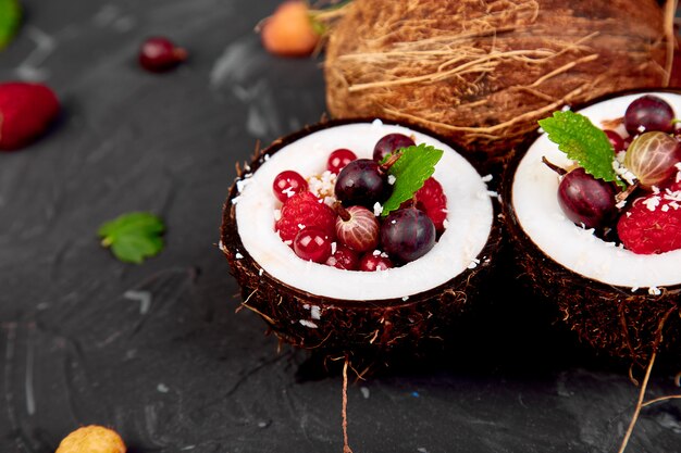 Salada de frutas agrus, groselha, rasbberry em tigela de casca de coco