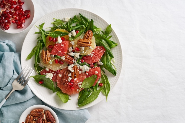 Salada de frutas cítricas de vista superior com nozes, alface verde. Espinafre com laranja, toranja, noz-pecã