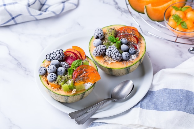 Salada de frutas com iogurte em tigela de melão esculpido