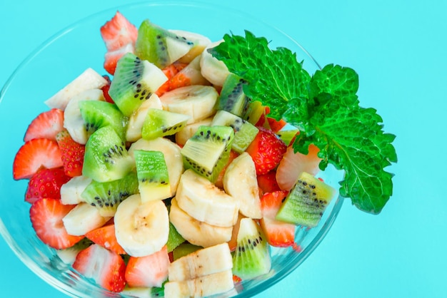 Salada de frutas com morango kiwi laranja e limão no fundo de madeira Vista superior com espaço de cópia