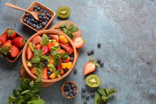 Salada de frutas de verão com laranjas, morangos, mirtilos, kiwi e hortelã fresca