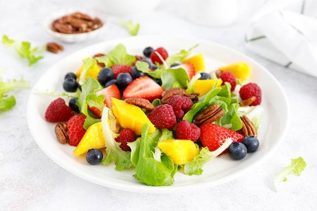 Salada de frutas e bagas com morango, mirtilo, framboesa, manga e nozes pecan Dieta alimentar saudável