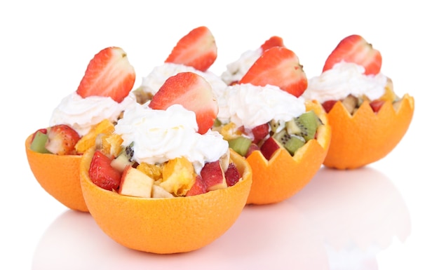 Salada de frutas em laranja oca isolada no branco
