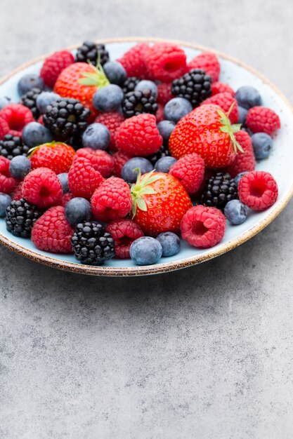 Salada de frutas frescas em um prato sobre uma superfície de madeira. Camada plana, vista superior, espaço de cópia.