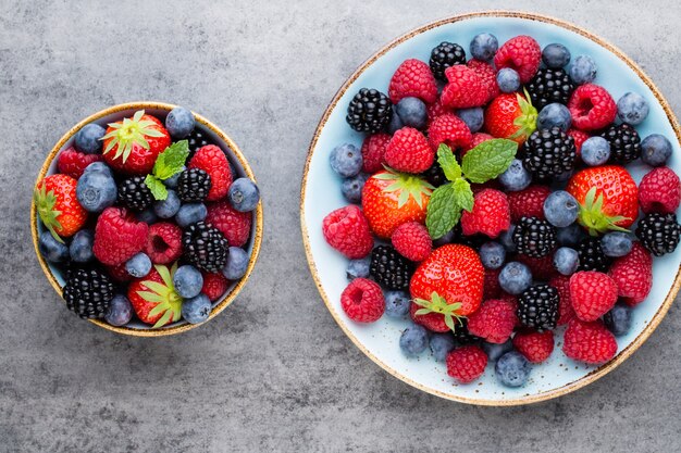 Salada de frutas frescas em um prato sobre uma superfície de madeira. Camada plana, vista superior, espaço de cópia.