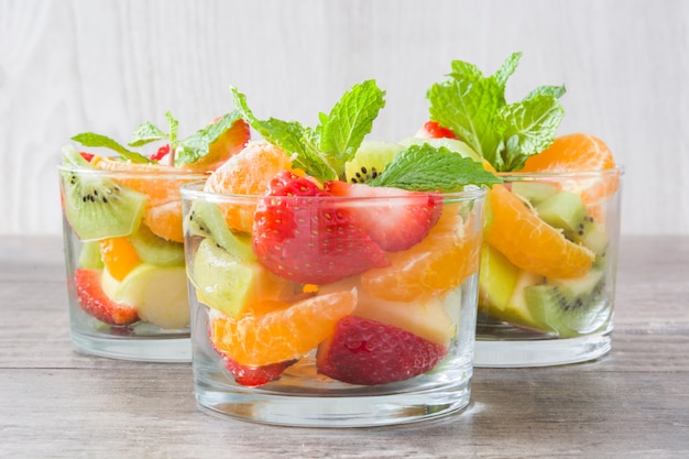 Foto salada de frutas frescas em vidro na mesa de madeira