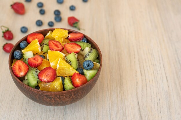 Salada de frutas saudável na tigela na luz