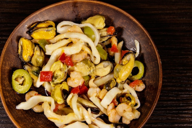 Salada de frutos do mar com lulas de camarão e mexilhões na mesa de madeira