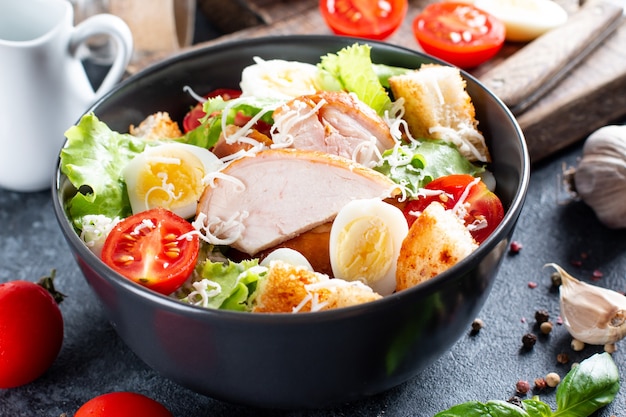 Salada de galinha. salada césar de frango. salada caesar com frango defumado em um prato. peito de frango grelhado e salada fresca no prato