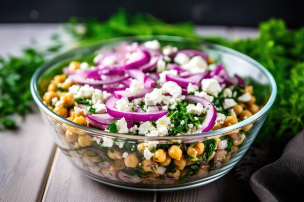 Foto salada de grão de bico com cebola roxa e queijo feta em uma tigela de vidro