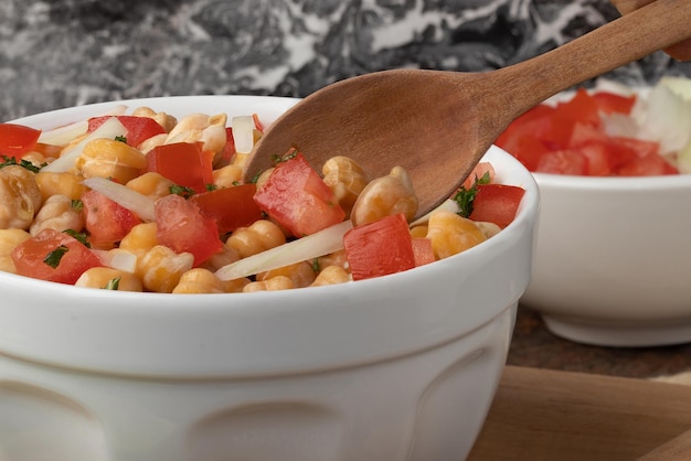 Salada de grão de bico com tomate, alho e cebola Foco seletivo Conceito de comida saudável