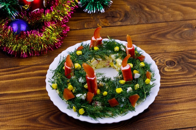 Salada de guirlanda de natal e decorações de natal em uma mesa de madeira