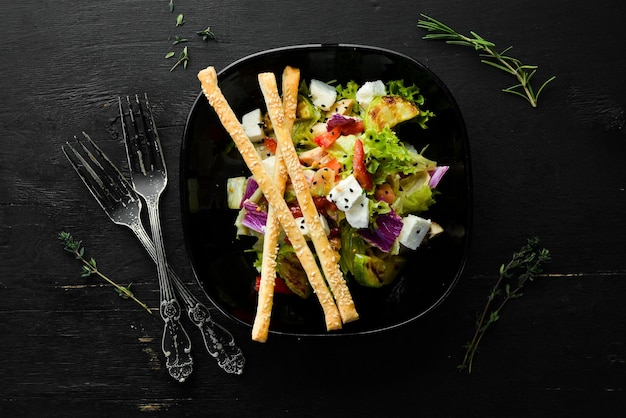 Salada de legumes com abobrinha de frango e queijo feta em um prato preto Vista superior Espaço livre para o seu texto