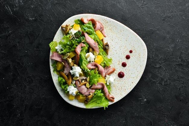 Salada de legumes com cogumelos e bacon em um prato Vista superior espaço livre para o seu texto Estilo rústico