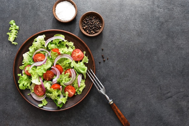 Salada de legumes com tomate, cebola roxa e molho preto, vista superior