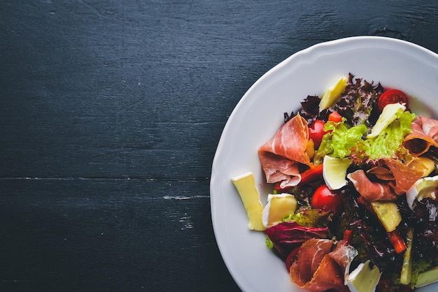 Salada de legumes e carne em cubos Em um fundo de madeira Vista superior Espaço livre