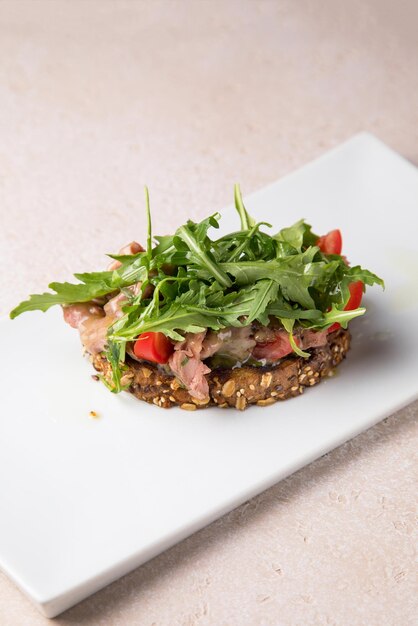 Salada de legumes e prato branco sobre fundo cinza Salada com tomates cebolas pepinos