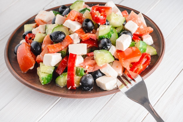 Salada de legumes em uma mesa de madeira branca