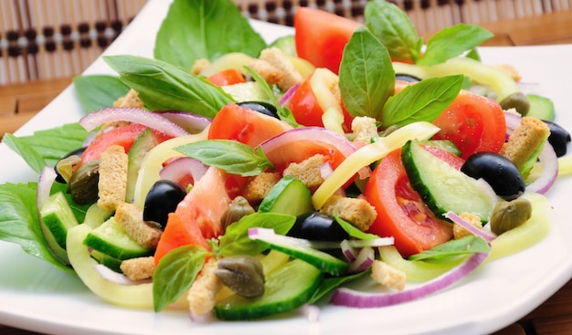 Foto salada de legumes fresca com manjericão, alcaparras, azeitonas, marinada com croutons