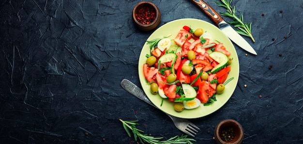 Salada de legumes fresca de tomates, pepinos, azeitonas e ovos. Salada dietética. Espaço para texto