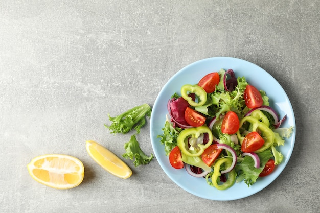 Salada de legumes frescos em fundo cinza