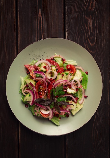 Salada de legumes georgiana tomates com pepinos cebola vermelha noz sementes de romã vista superior sem pessoas