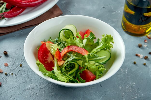 Salada de legumes leve de alface, tomate e pepino em uma tigela branca. Salada vegetariana