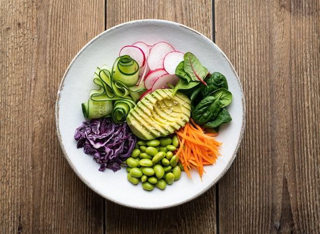 Salada de legumes na vista superior de comida saudável de fundo de madeira