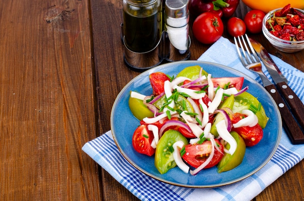 Salada de legumes saudável com tomate e pedaços de lula. Foto do estúdio.