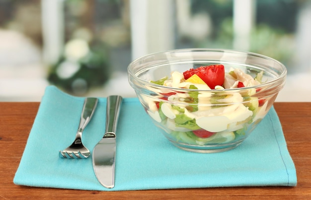 Salada de lula com legumes em uma tigela de vidro na mesa de madeira closeup