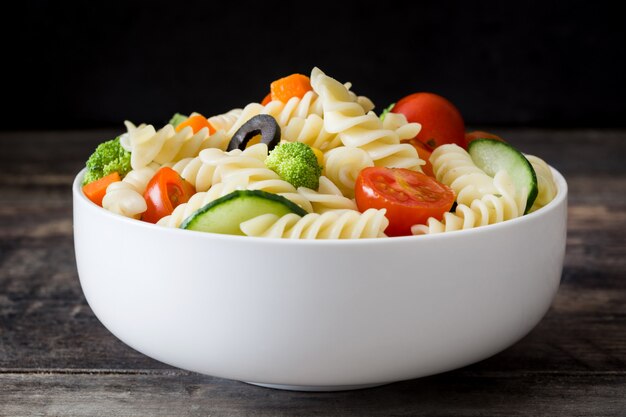 Salada de macarrão em uma tigela na mesa de madeira