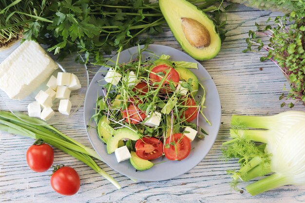 Salada de microgreens abacate tomate queijo e rúcula em um prato