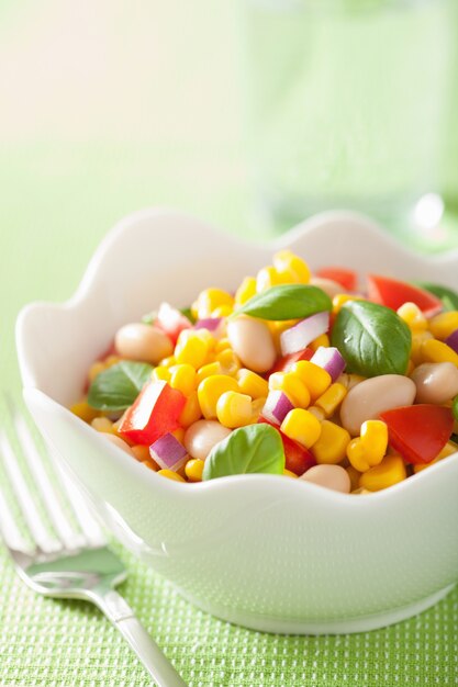 Salada de milho saudável com tomate, cebola, feijão branco, manjericão