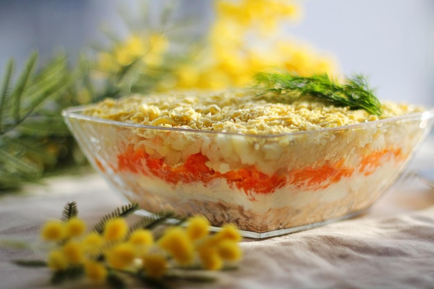 Salada de mimosa russa tradicional com batatas de ovos de peixe e cenouras