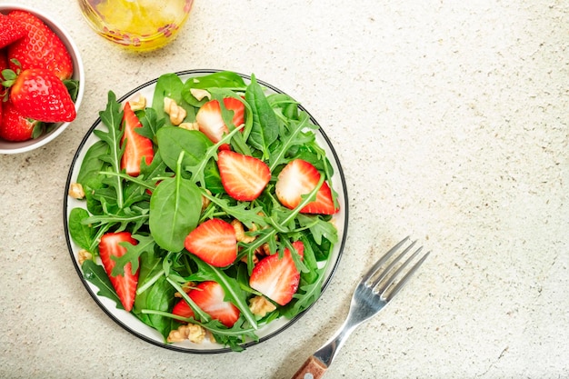 Salada de morango com espinafre rúcula nozes queijo azul na mesa cinza Comida saudável Vista superior