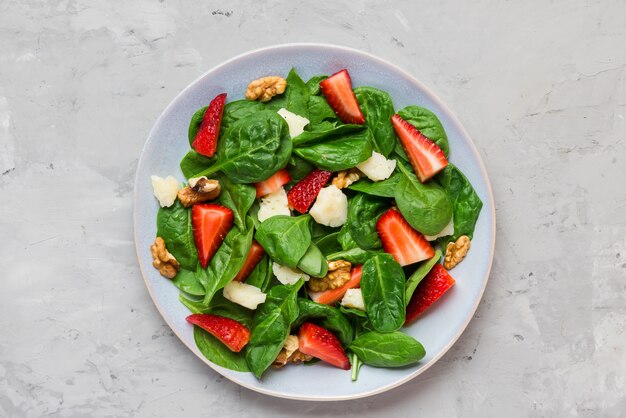 Salada de morango fresca com folhas de espinafre, queijo parmesão e nozes. dieta alimentar saudável