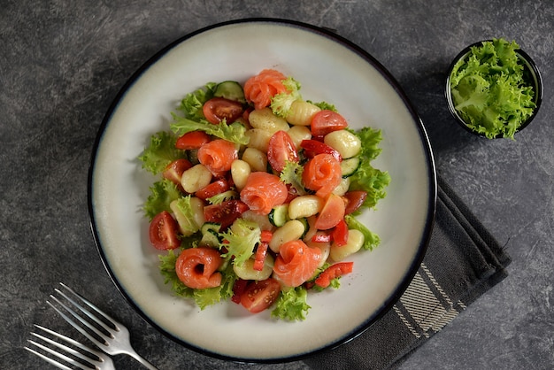 Salada de nhoque de batata com tomate, pepino, pimentão, salmão e alface