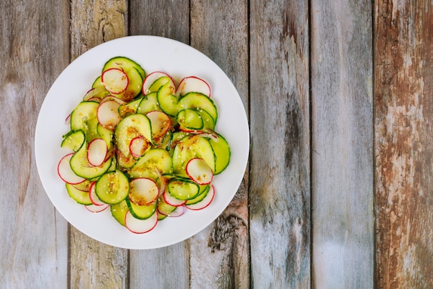 Salada de pepino e rabanete na mesa de madeira