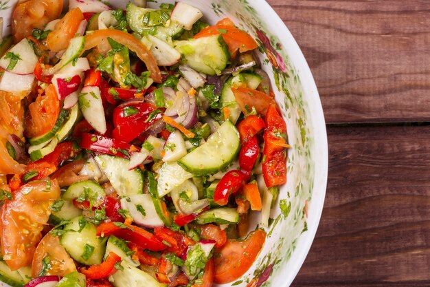 Salada de pepino e tomate com cebola na mesa de madeira