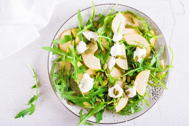 Salada de pêra com queijo de rúcula e sementes de abóbora em um prato Almoço caseiro Vista superior Closeup