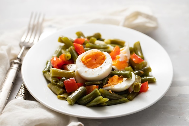 Salada de pimenta de feijão verde e ovos cozidos na chapa branca